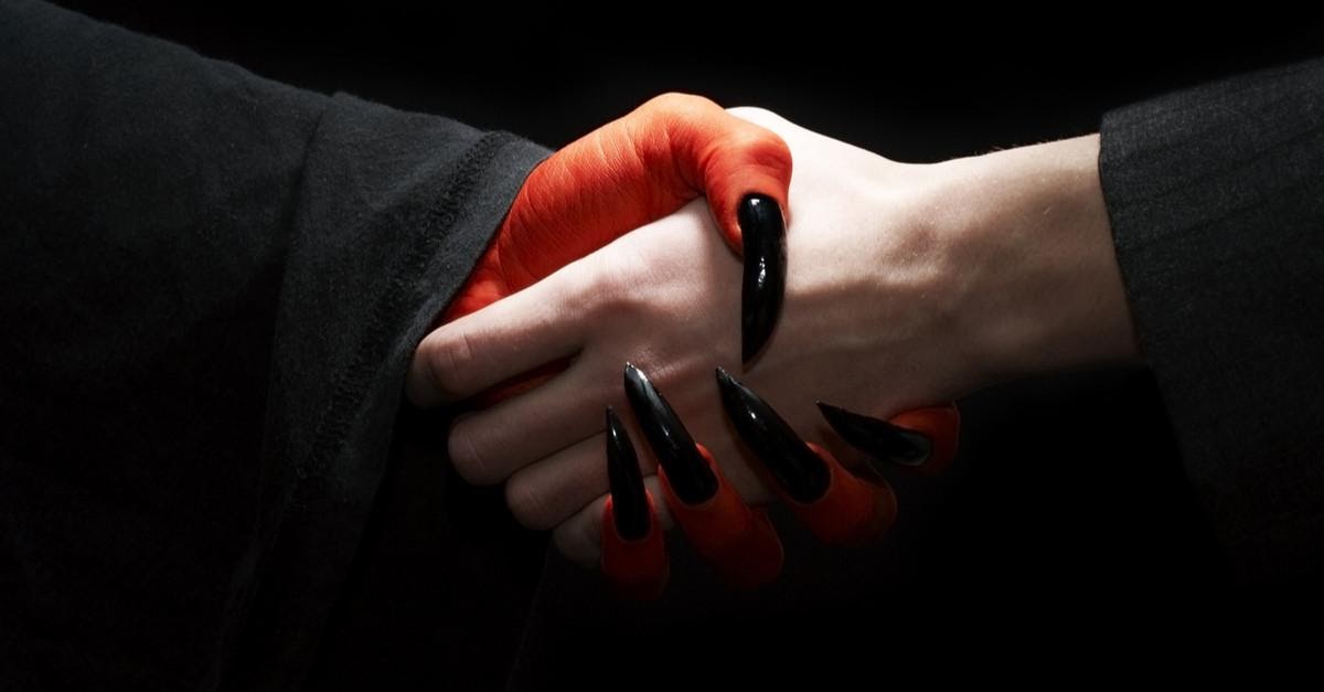 a person shaking hands with a devil
