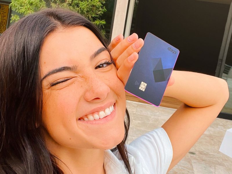 Chali D'Amelio holding a step card