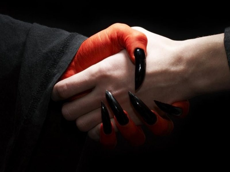 a person shaking hands with a devil