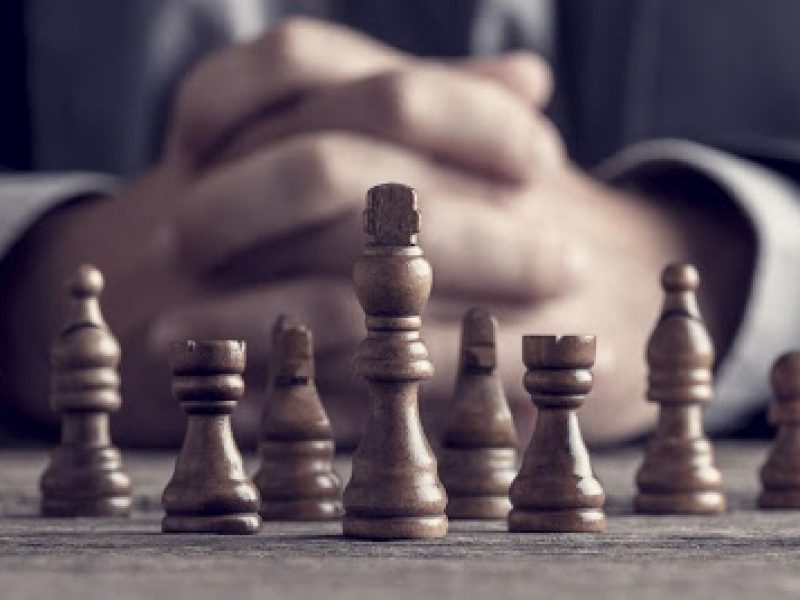 man sitting behind chess board